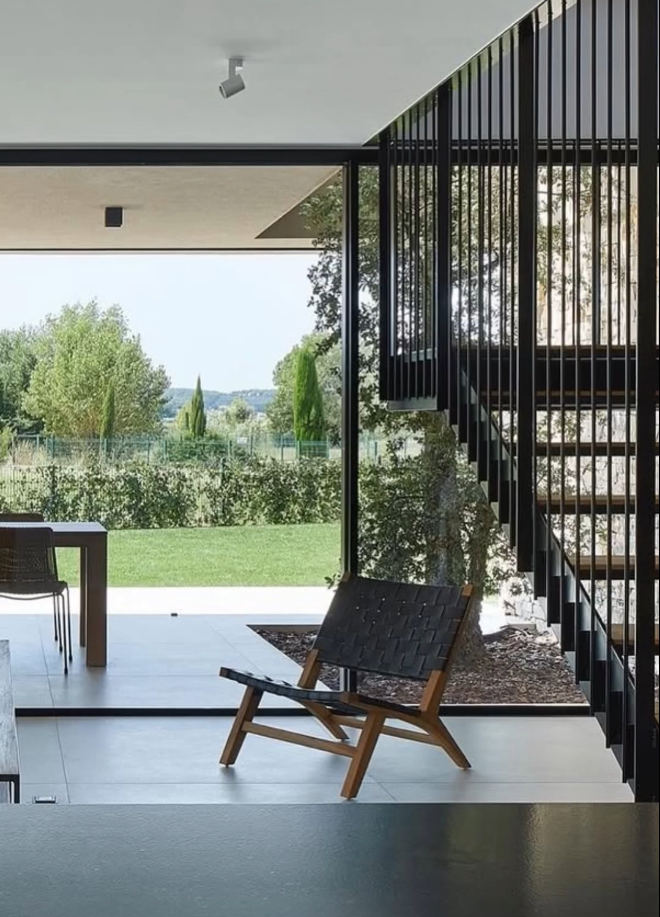 Espai exterior d'un habitatge contemporani amb butaca i estructura metàl·lica negra