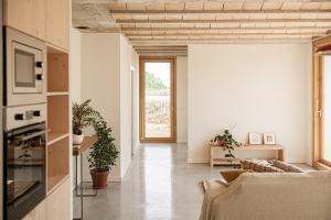 Sala d'estar d'un habitatge rehabilitat amb fusta, parets blanques i llum natural